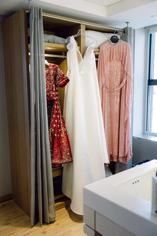 Photo of bride's dress and lehenga hanging up.