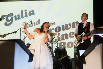 Bride and groom performing on stage with groom’s band.