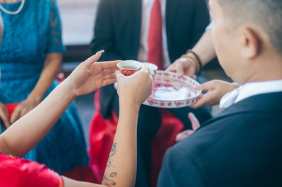 Bride takes teacup off of tray to give to elders.