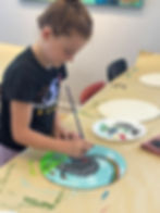 girl painting on canvas during kids art classes at the prairie arts center in north platte nebraska