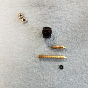 A precision-machined brass needle replacement shown next to an aluminum housing after a successful extraction and repair built by high country mfg colorado