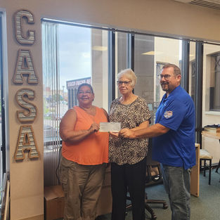 Board Member Sheri Cecil, Derek Beck and Executive Director Janet Vath check presentation from Schmidt Family Foundation and Eagle Communications to Lincoln County Casa