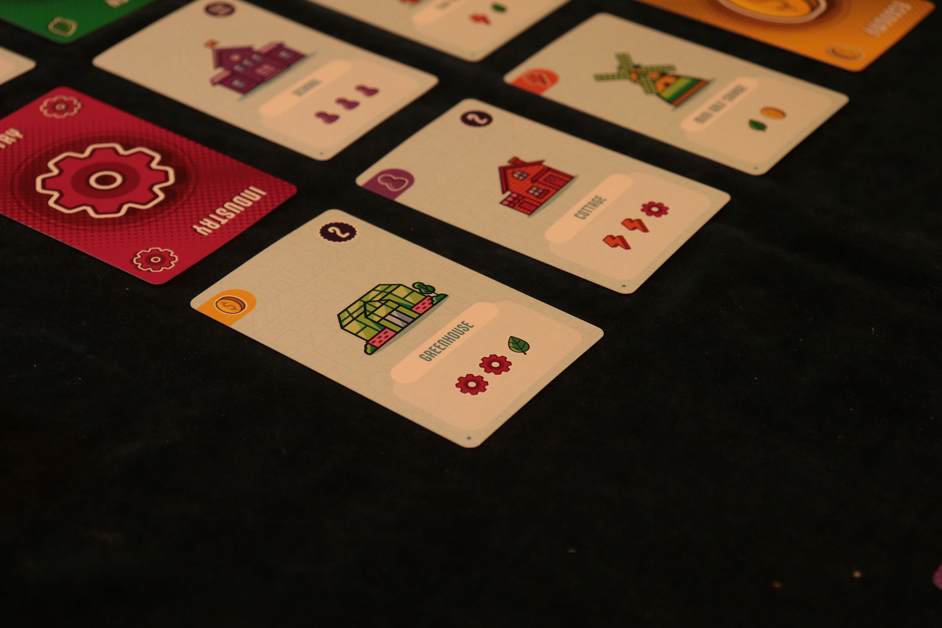 A close up of some cards in the Market of a game of Point City. In the left hand corner is a Greenhouse.