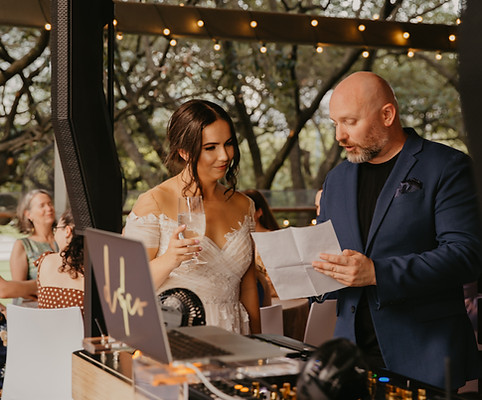 Wedding DJ Mike speaking with a bride during a reception at The Grove in Houston, a luxury wedding venue, by D&Co Entertainment.