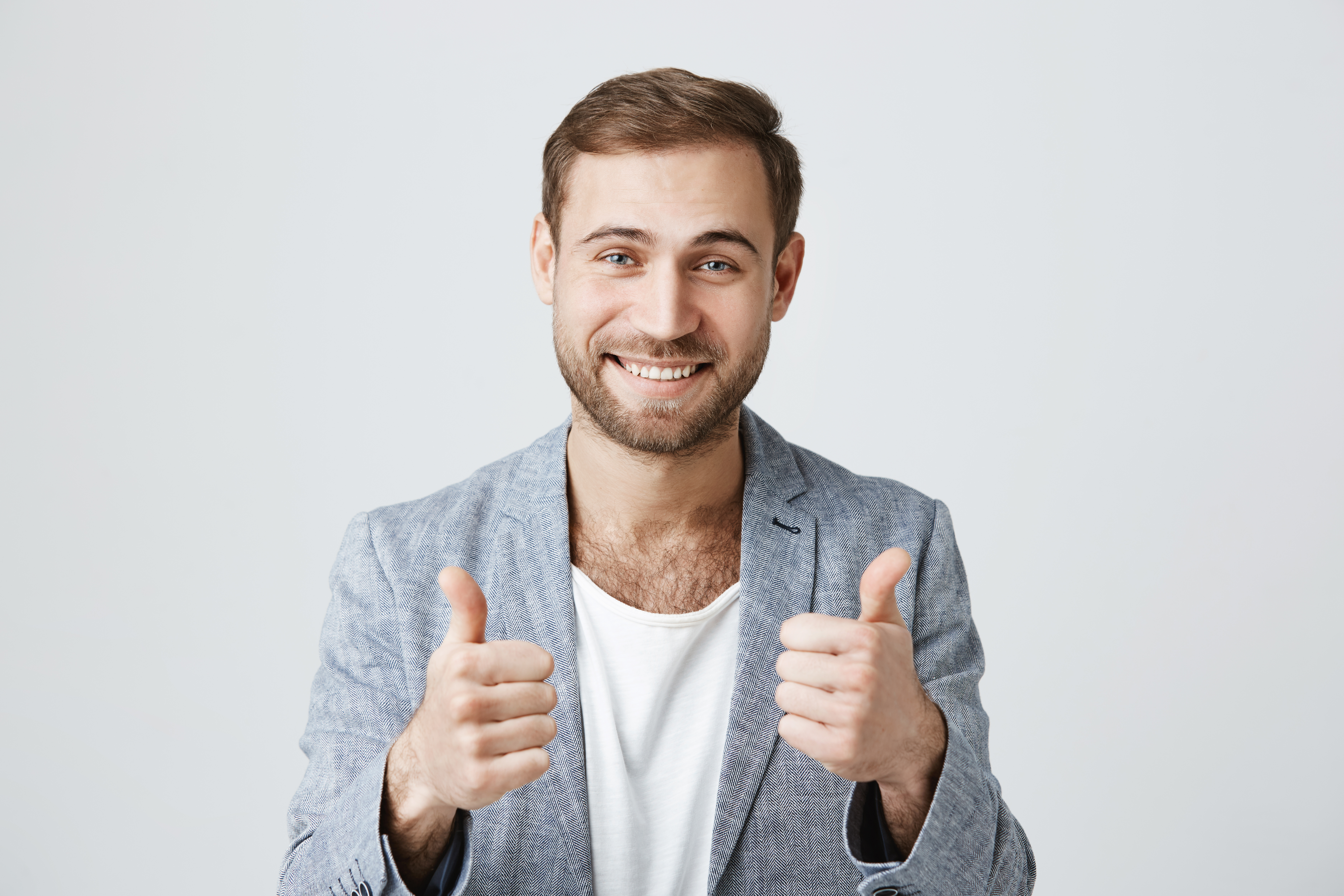 Smiling man gives two thumbs up