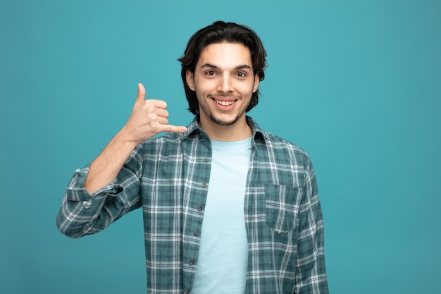Smiling man making a call me hand gesture