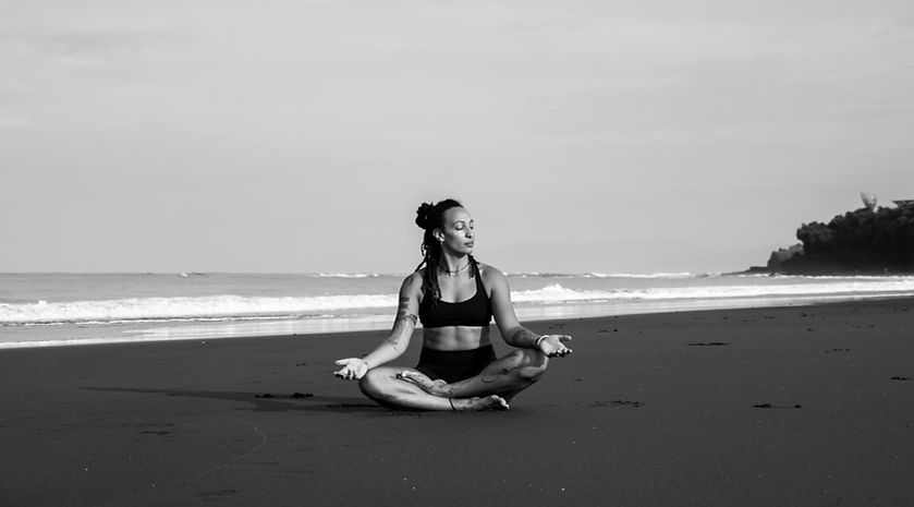 Sitting crosslegged on a beach, meditating