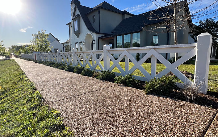 Custom white crossbuck fence built for residential property, adding curb appeal and durable security.