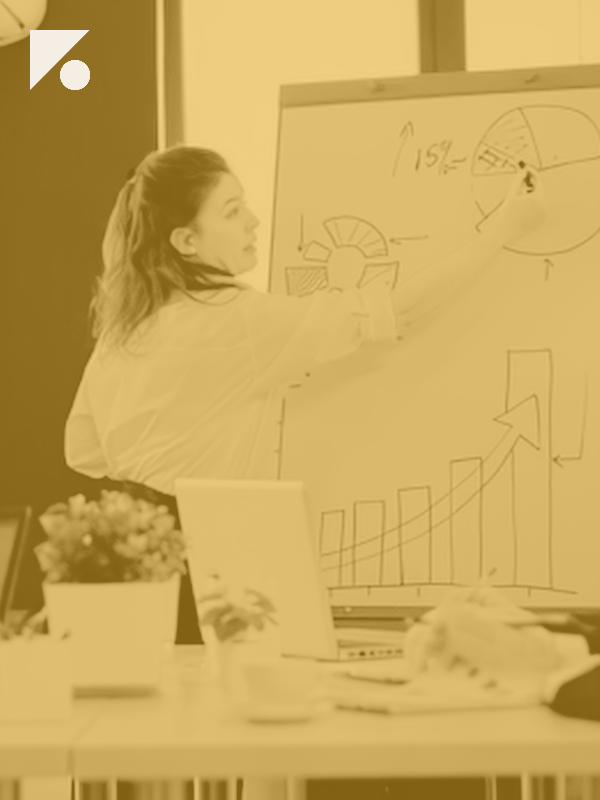 Team leader sketching charts on a whiteboard while walking a team through shared decision criteria