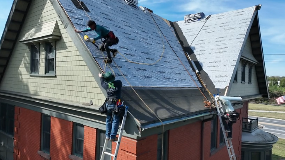 Eye-level view of a roofing contractor inspecting a residential roof