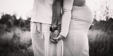 a man with a tattoo on his arm holds a woman 's hand