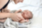 Tender moment: Expert Newborn & Maternity Care in the UAE. Caregiver gently cradles sleeping newborn, suggesting skilled, nurturing support.