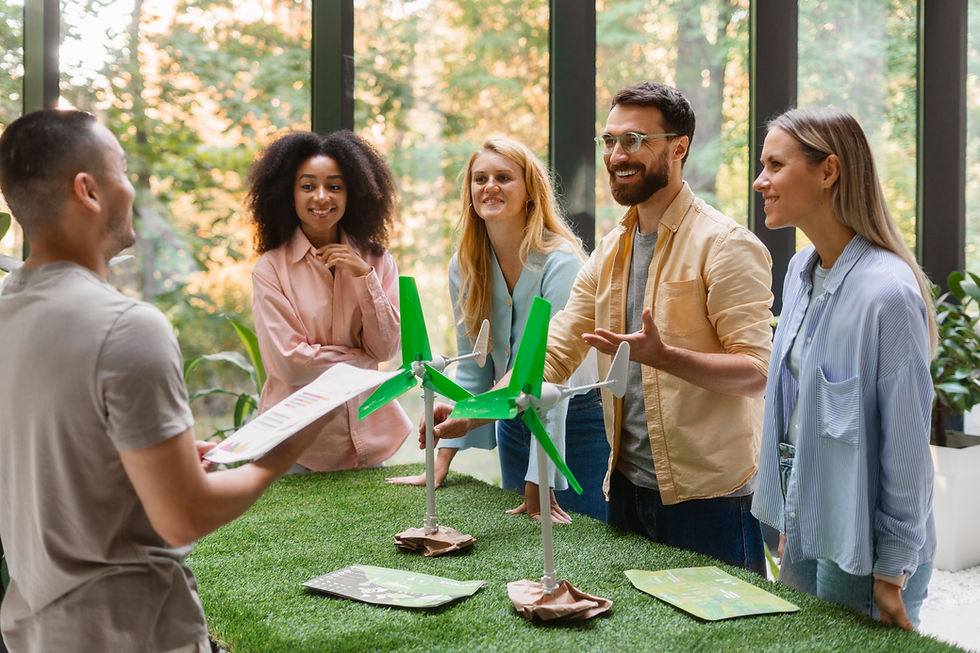 A diverse group of colleagues discusses sustainability, gathered around wind turbine models on a grassy table to **Demonstrate ESG Efforts**.