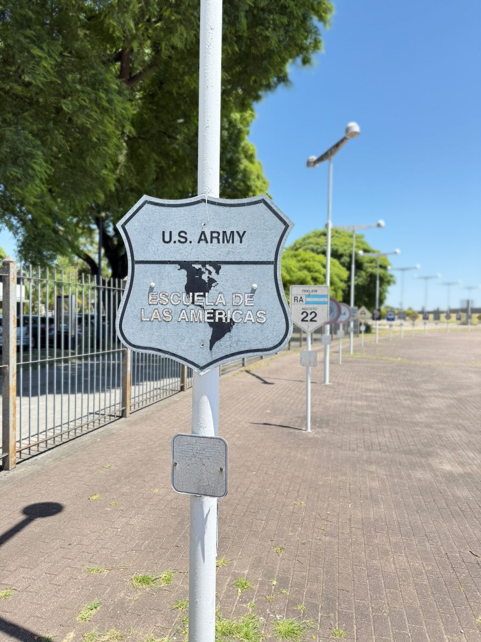 Sign at Parque de la Memoria reading “U.S. Army – Escuela de las Américas,” referencing U.S. military training of Latin American officers.