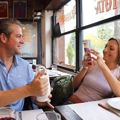 Two guests enjoying an Argentine food tour in Buenos Aires, capturing the experience at a traditional neighborhood restaurant.