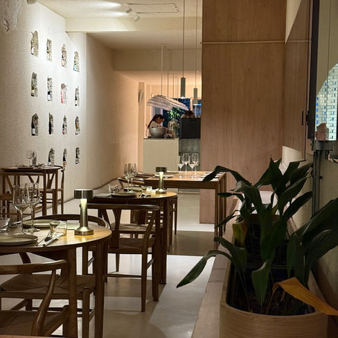 Interior of Horta restaurant with wooden tables, soft lighting and minimalist decor.