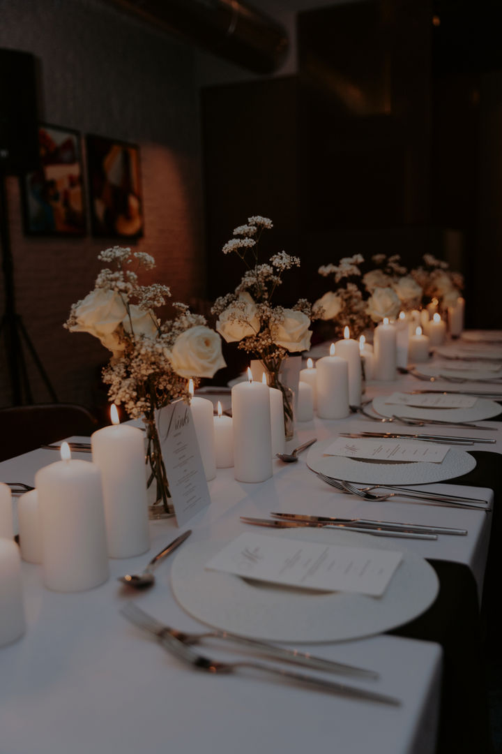 Elegant table setting with white candles and roses