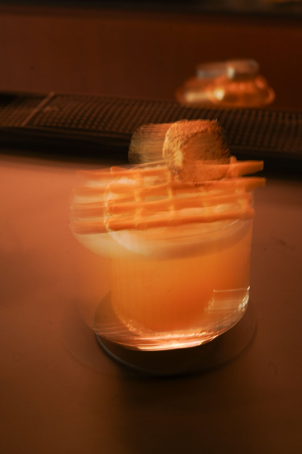 Craft cocktail with orange garnish in a lowball glass