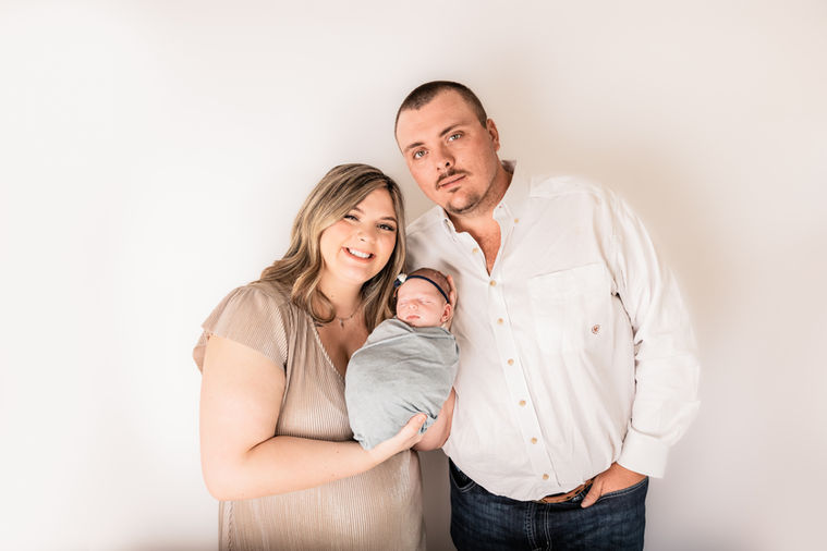 Beautiful family with their newborn baby girl in studio.