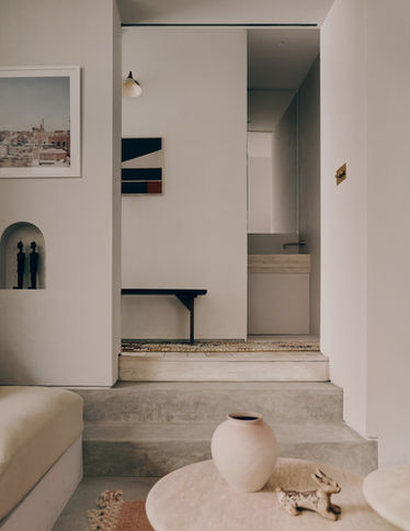 conversation pit, low sofa, deep sofa, bespoke sofa, stone coffee table, moroccan rug, sheer curtain, large vase, soft light, modern architecture, soft minimal, residential architecture, arch niche, level change, wall light