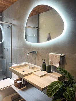 cuba para banheiro esculpida em pedra com bancada incluída no design. A bancada e cuba são peças únicas para um banheiro de luxo