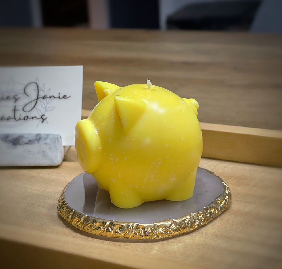 Bougie jaune en forme de cochon, texte Janie Créati, Cocker anglais bougie sur une table.