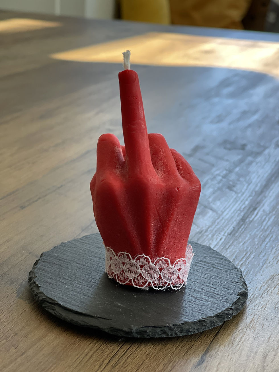 Red candle in the shape of a hand with a middle finger displayed. Bougies Janie Créati