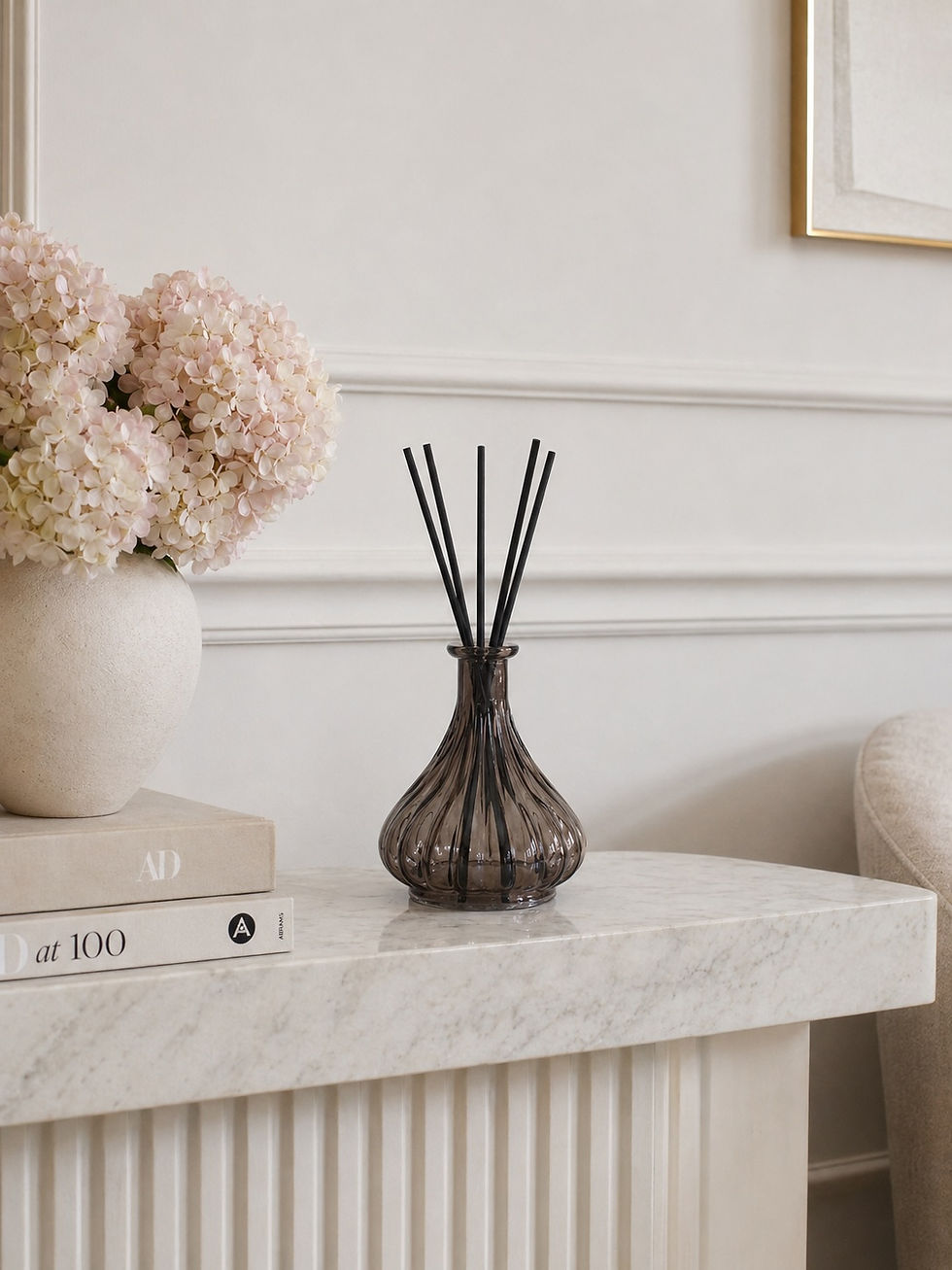 Luxury ribbed glass reed diffuser with black reeds on marble kitchen island by Whispering Lily