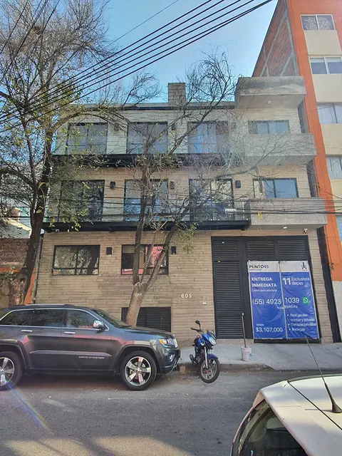 Fachada exterior de un desarrollo de Altea Habitat con acabados en piedra natural, amplios ventanales en una zona residencial.