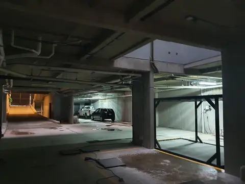 Área de estacionamiento subterráneo, mostrando una estructura de concreto reforzado y sistemas de elevautos para optimización de espacios.