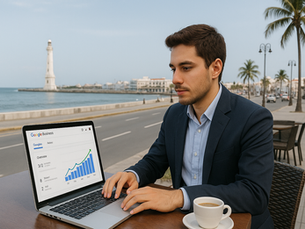 Empresario veracruzano consultando datos de marketing digital en su laptop mientras trabaja en un café local con vista al malecón de Veracruz.