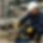 Técnico en planta industrial realiza prueba hidrostática ajustando manómetro conectado a tubería de gran tamaño, usando bomba manual de presión, casco, guantes y uniforme de seguridad.