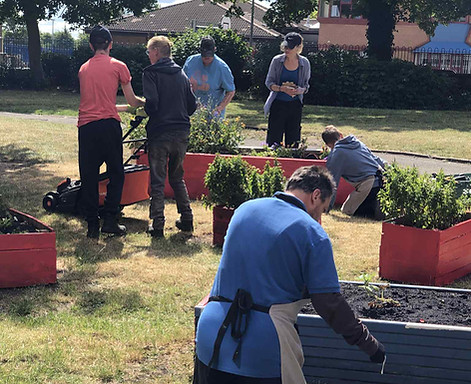 Community members gardening and painting planters.