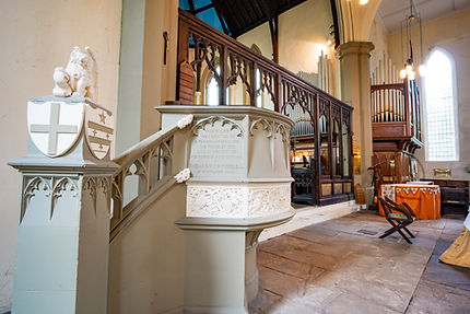 Intricate stone pulpit and wooden organ inside a historic church
