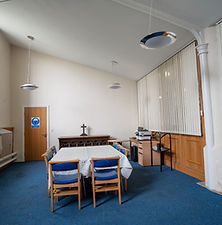 Meeting room with tables and chairs. Carpeted floor