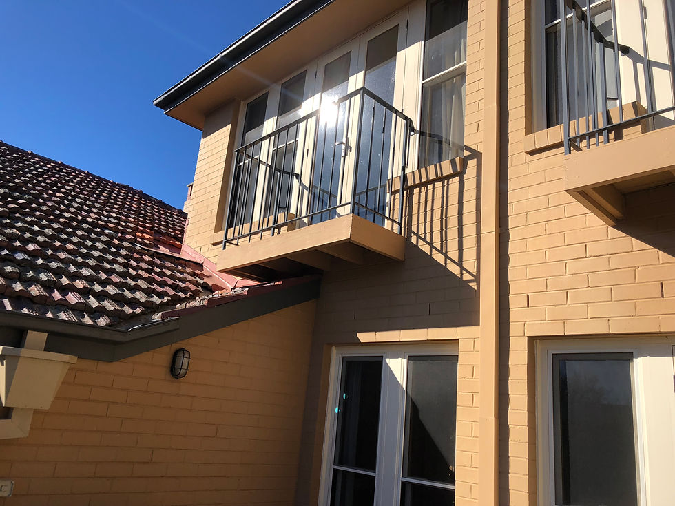 External of painted brick home, in full sun.