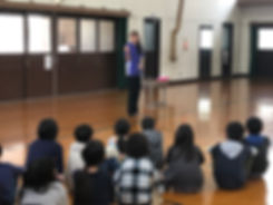体育館に座って話を聞いている様子
