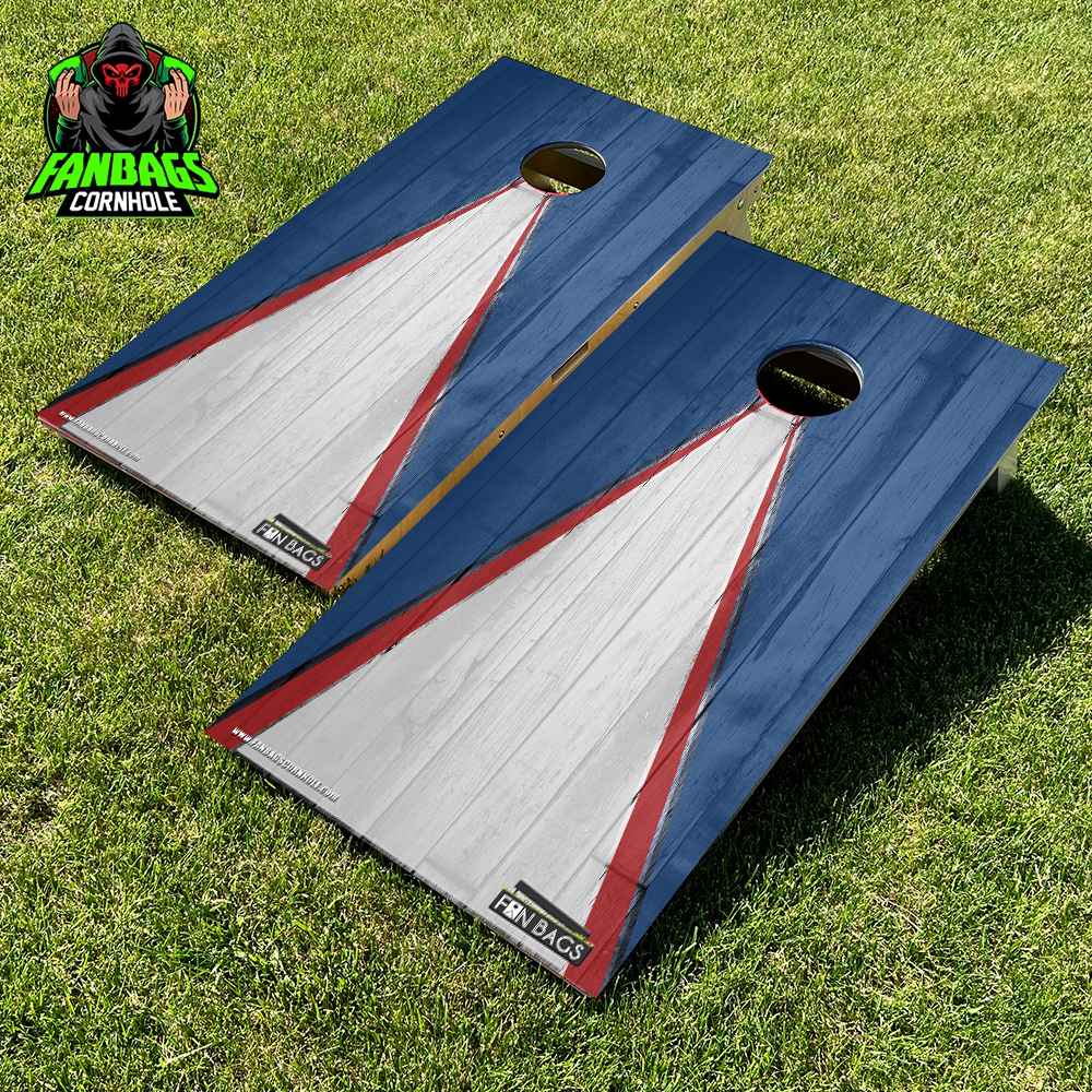 a set of cornhole boards sitting in grass with a blue and white triangle design