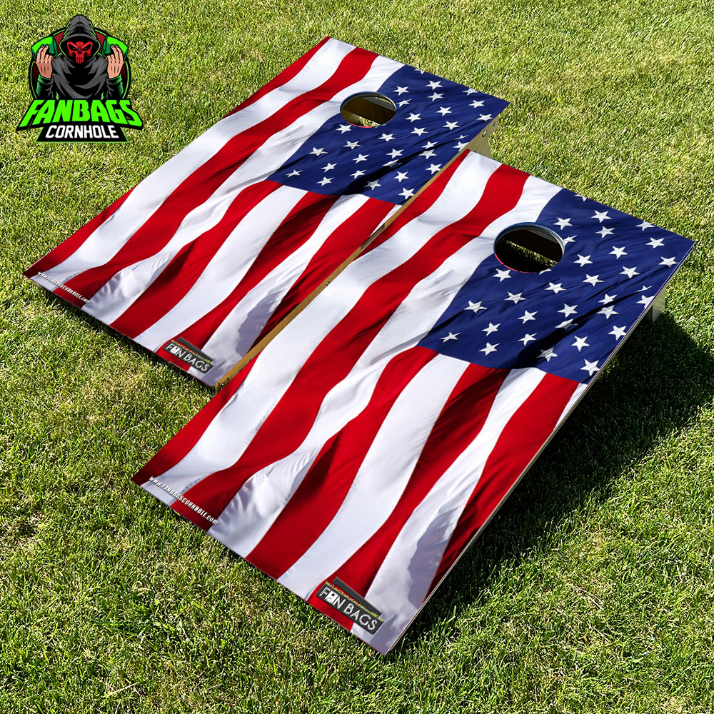 a set of cornhole boards sitting in grass with an American flag design