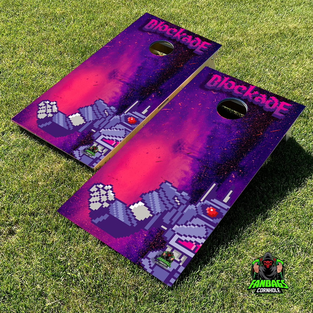 a set of cornhole boards sitting in grass with a the blockade logo