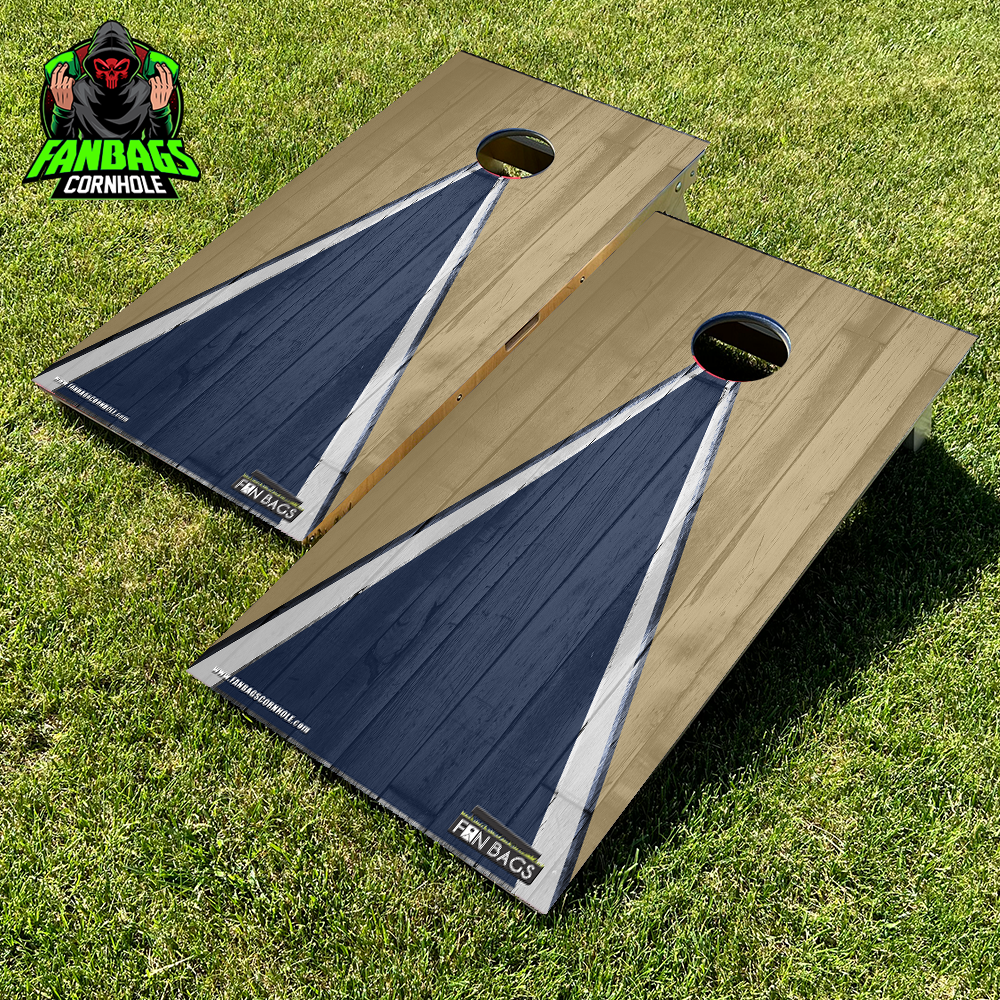 a set of cornhole boards sitting in grass with a yellow and blue triangle design
