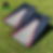 a set of cornhole boards sitting in grass with a blue and grey triangle design