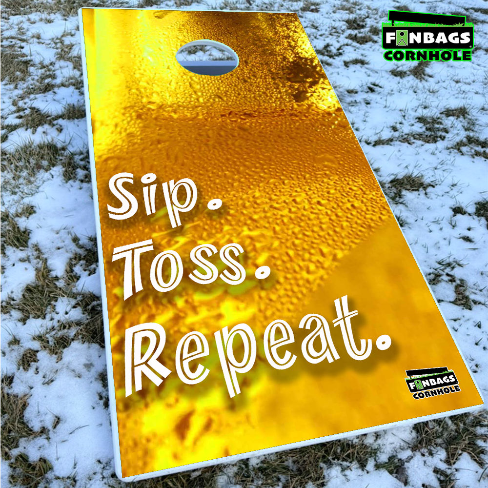 an all weather PVC cornhole board sitting in snow with a beer themed design printed directly on the top
