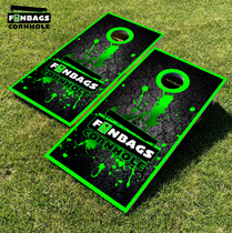 Two cornhole boards with a green border and green paint splatter