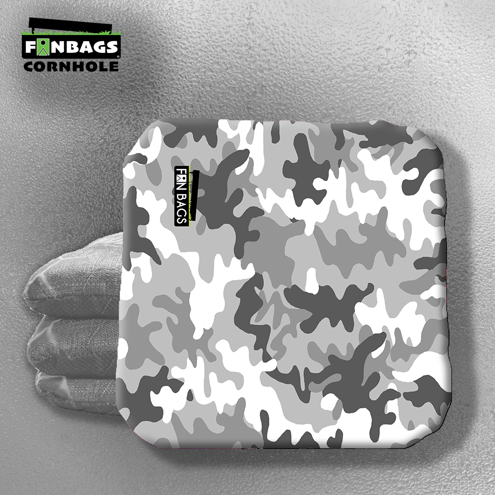 A set of four camouflage-themed cornhole bags laid out on a flat surface, featuring a rugged camo print in green, brown, and