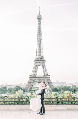 Bräutigam hebt seine Braut am Eiffelturm hoch