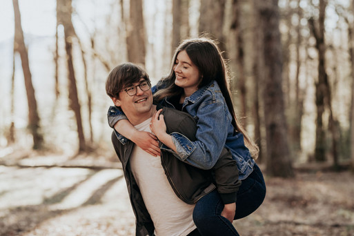 couple being playful in forest at engagement photos at cades cove in tennessee