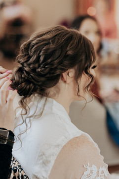 Bride gets hair styled for wedding day