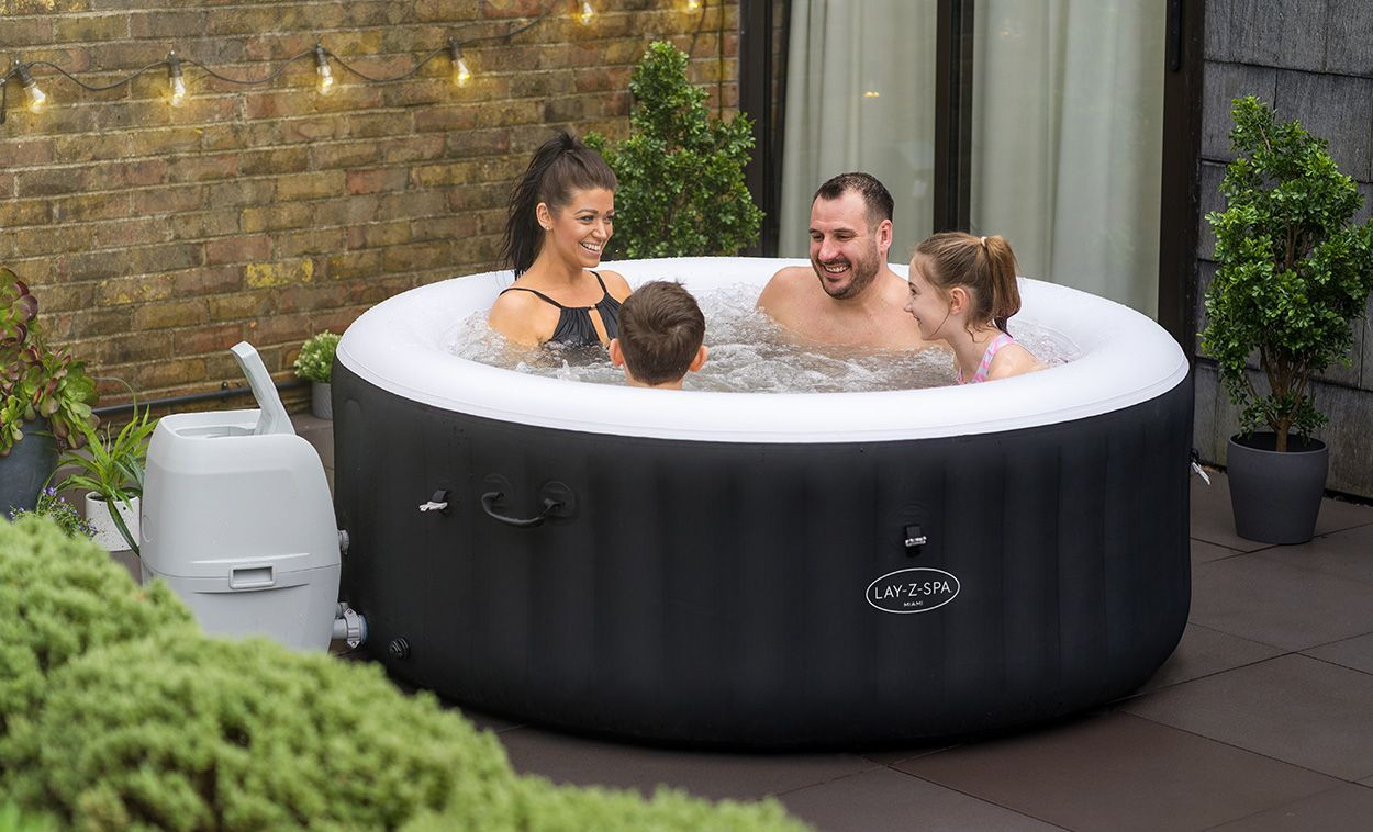 lay z spa miami with 4 people sat in it