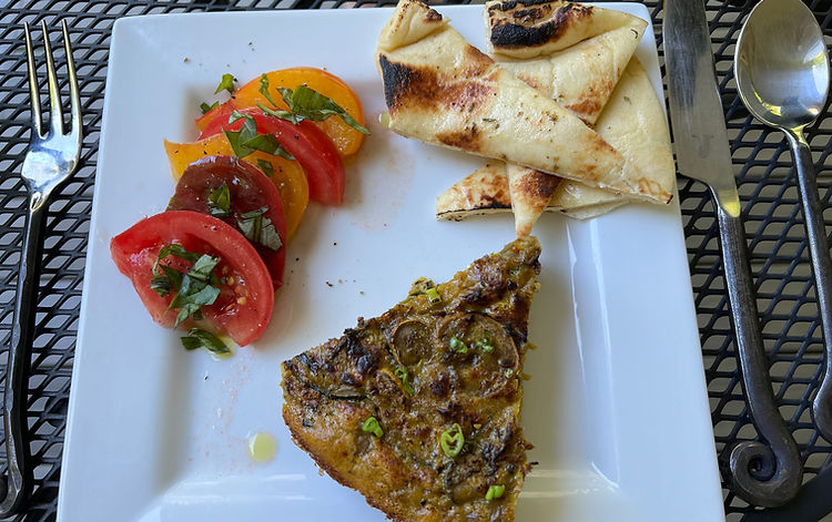Kuku Kadoo served with tomatoes and naan